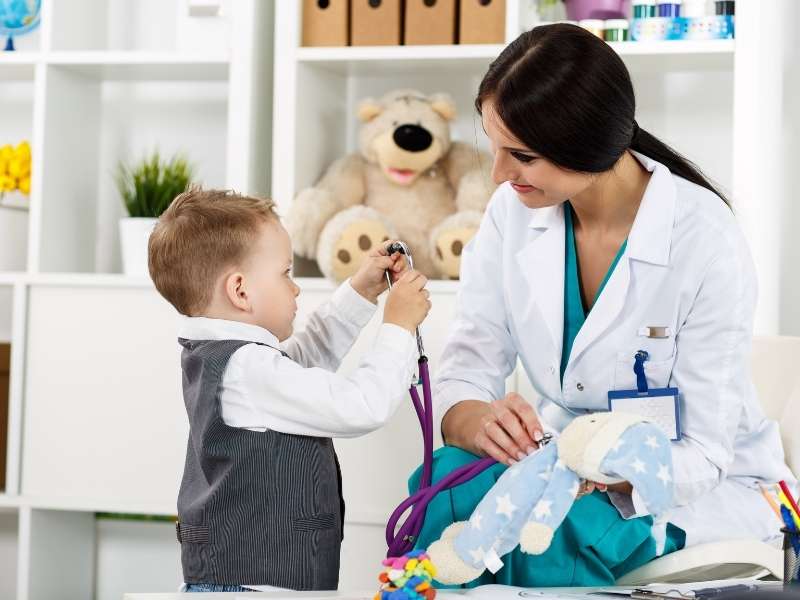 Médica e criança em consultório pediatrico.