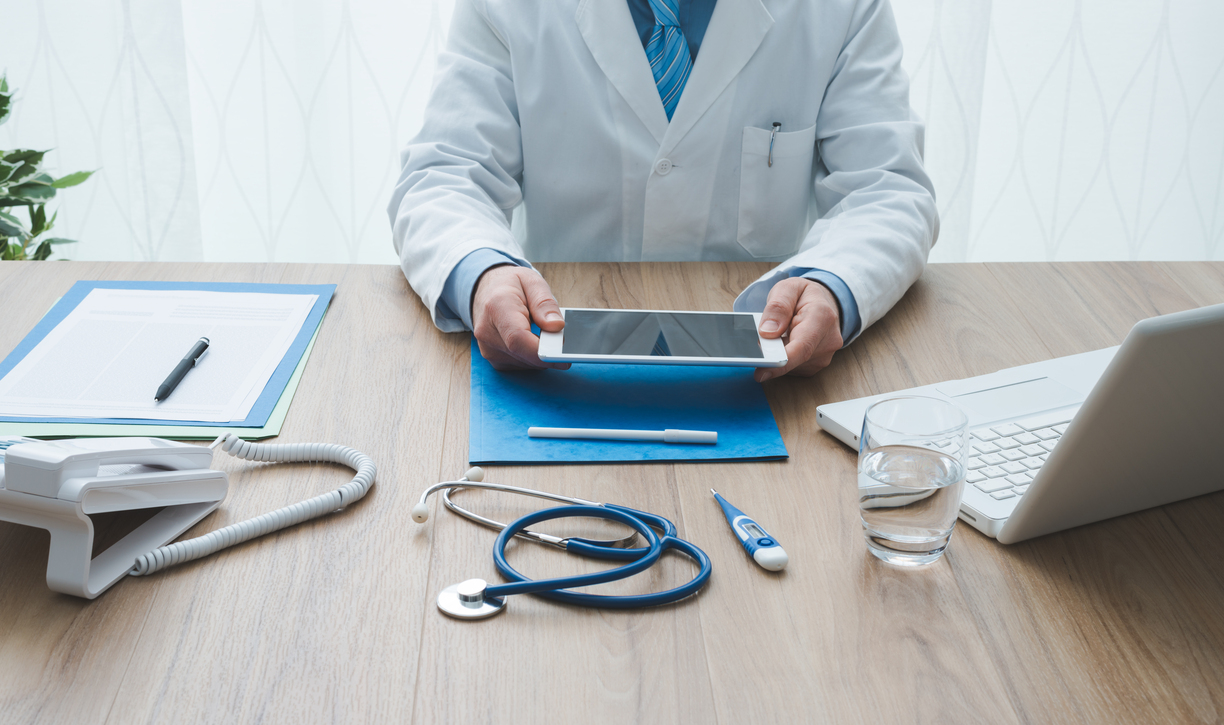 Médico profissional trabalhando na mesa do escritório, ele está usando um tablet digital, conceito de saúde e tecnologia