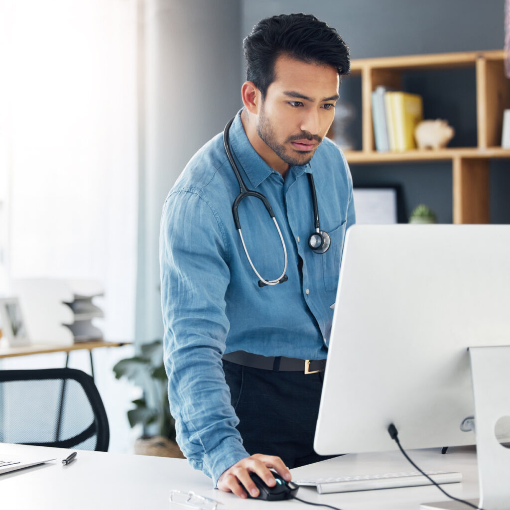 Homem médico mexendo no seu computador e resolvendo problemas de gestao