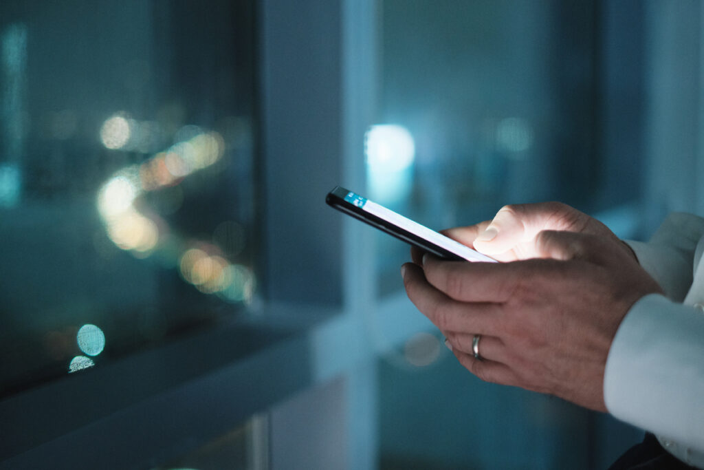 Mãos segurando o celular e fazendo um agendamento pelo whatsapp