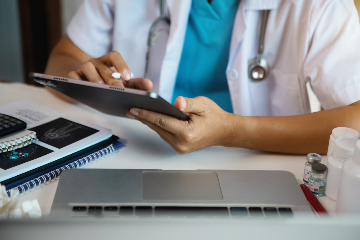 Médico trabalha em tablet digital tablet com tecnologia médica de saúde usando o computador em um consultório moderno pela manhã na mesa. - prescrição eletrônica