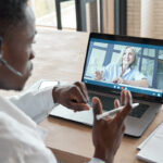 Médico consultando paciente idoso por videochamada on-line de telemedicina.